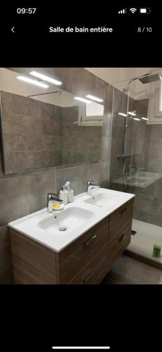 a bathroom with a sink and a mirror at Appartement spacieux, proche centre ville. in Ajaccio