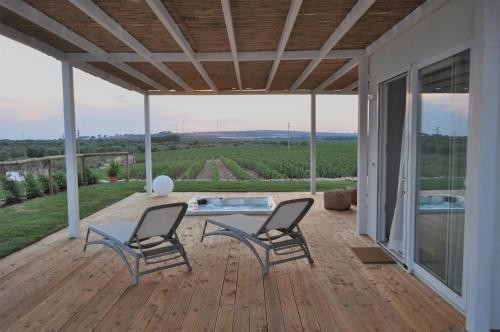 a patio with two chairs and a table and a hot tub at Methe in Lizzano