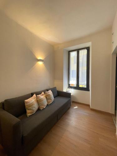 a living room with a black couch and a window at Easy Milano - Rooms and Apartments Navigli in Milan