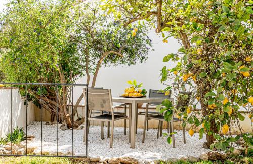 eine Terrasse mit einem Tisch und Stühlen unter Bäumen in der Unterkunft Finca El Limonar in Alora