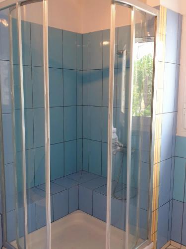 a shower in a room with blue tiles at HOUSE SUITES DOMAINE in Rizómilos