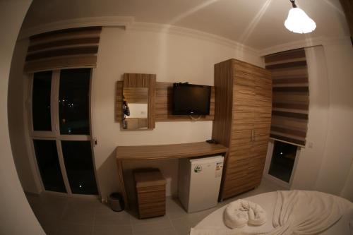 ein Schlafzimmer mit einem Bett und einem TV in einem Zimmer in der Unterkunft Araucaria Pension in Antalya