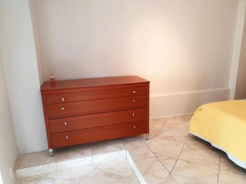 a bedroom with a wooden dresser next to a bed at HOUSE SUITES DOMAINE in Rizómilos