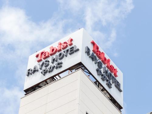 een bord bovenop een gebouw bij Tabist Rays Hotel Yakata in Miyazaki