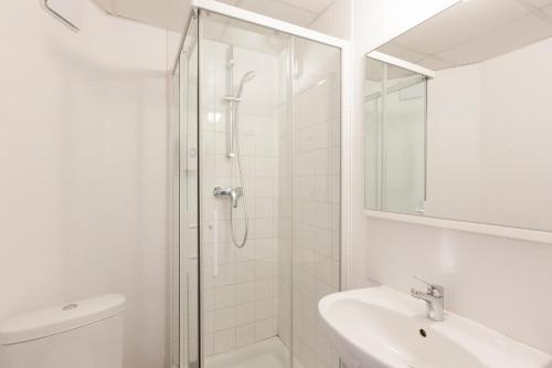 a white bathroom with a shower and a sink at Hôtel F1 Reims Tinqueux in Reims