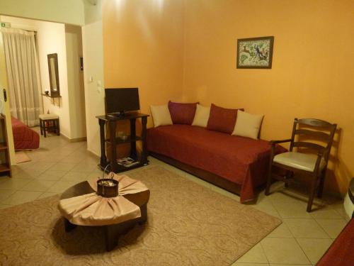 a living room with a red couch and a chair at Eu Zin in Vytina