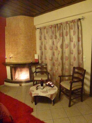 a living room with two chairs and a fireplace at Eu Zin in Vytina