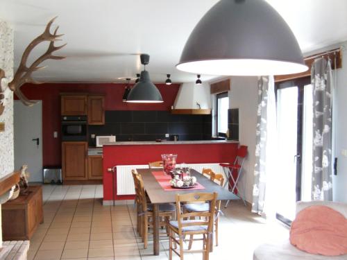 Gîte Les Framboisiers في نوفشاتو: مطبخ وغرفة طعام مع طاولة وكراسي