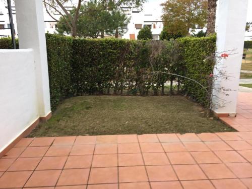a garden with a hedge and a yard at Jardin 10 1071 in El Romero