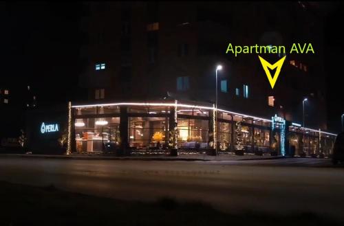a building with a sign on it at night at AVA Apartment Istočno Sarajevo in Lukavica