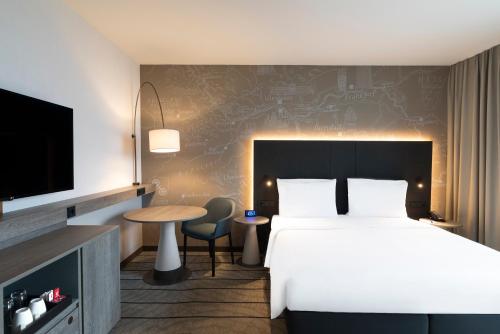 a hotel room with a bed and a tv at Hyatt Place Frankfurt Airport in Frankfurt