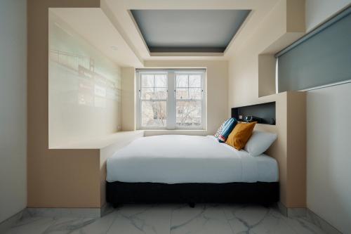 a bedroom with a bed and a window at Cozy M Hostel in Sydney