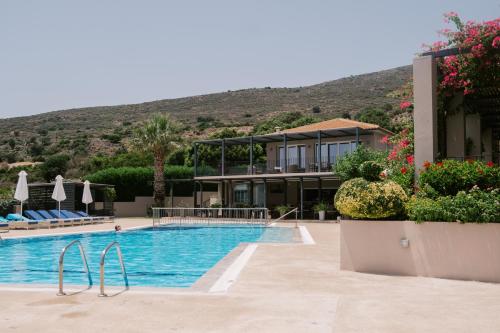 un complejo con una piscina con una montaña en el fondo en Blue Jasmine Hotel, en Skala