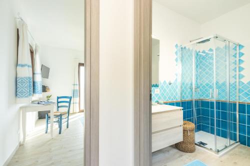 een badkamer met blauwe betegelde muren en een spiegel bij Sa Domm'e Galleria in Baunei