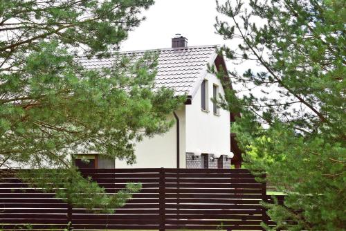 a white house with stairs and trees at Holiday House Strawberry in Druskininkai