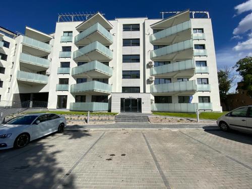a white car parked in front of a building at Apartamenty Białe nad jeziorem Białym in Augustów