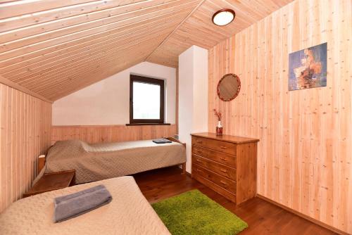 a bedroom with a bed and a wooden ceiling at Holiday House Strawberry in Druskininkai