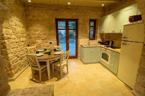 a kitchen with a table with chairs and a refrigerator at Harmony Seaview Villas In Elafonisos in Elafonisos