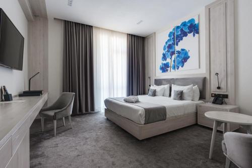 a bedroom with a bed and a tv and a table at Hotel Inspira-S Tashkent in Tashkent
