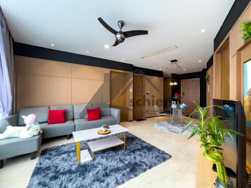 a living room with a blue couch and red pillows at Vortex Premium Suites KLCC by SCHIEN in Kuala Lumpur