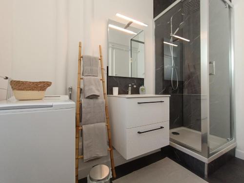 La salle de bains est pourvue d'une douche, d'un lavabo et d'un miroir. dans l'établissement L'Atelier d'Oscar, au Havre