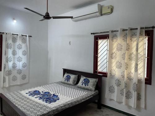 a bedroom with a bed and a window with curtains at WHITE HOUSE- 1BK Pleasant Apartment with Open Terrace in Coimbatore