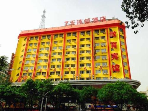 un edificio amarillo y rojo con sillas encima en 7Days Inn Xi'an North Street Subway Station Lianhu Park, en Xi'an