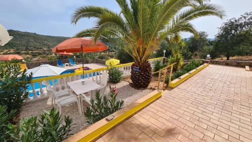 ein Resort mit einer Palme und einem Pool in der Unterkunft Casa Branca Holiday Resort in Salir