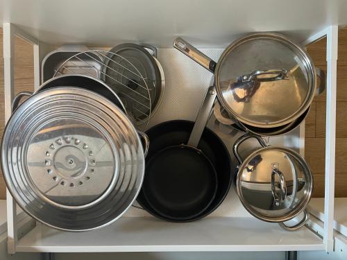 a bunch of pots and pans sitting on a shelf at Au cœur du vieux Toulon au calme appartement rénové climatisé confortable étage élevé avec ascenseur proche parking et toutes commodités in Toulon