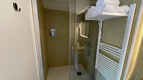 La salle de bains est pourvue d'une cabine de douche en verre. dans l'établissement Au cœur du vieux Toulon au calme appartement rénové climatisé confortable étage élevé avec ascenseur proche parking et toutes commodités, à Toulon