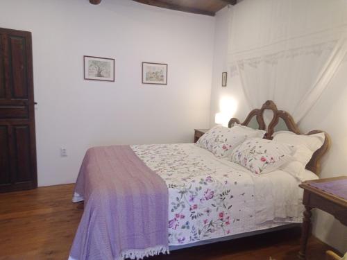 a bedroom with a bed with a purple blanket on it at Charming cottage in the heart of the Ribera sacra in Castro Caldelas