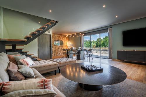 a living room with a couch and a table at Pyrénées Prestige - Villas d'exceptions et hébergements insolites in Argelès-Gazost