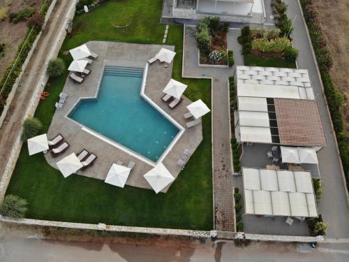 an overhead view of a swimming pool with white furniture at Callisto Seaside Homes & Suites in Marathopolis