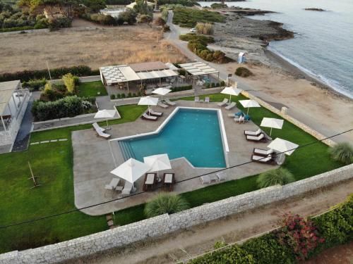 an overhead view of a swimming pool with chairs and umbrellas at Callisto Seaside Homes & Suites in Marathopoli