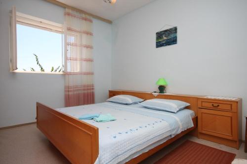 mała sypialnia z łóżkiem i oknem w obiekcie Rooms by the sea Sucuraj, Hvar - 6734 w mieście Sućuraj
