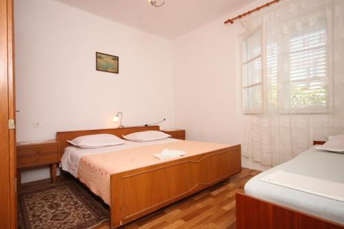 a bedroom with a wooden bed and a window at Rooms by the sea Sucuraj, Hvar - 6734 in Sućuraj