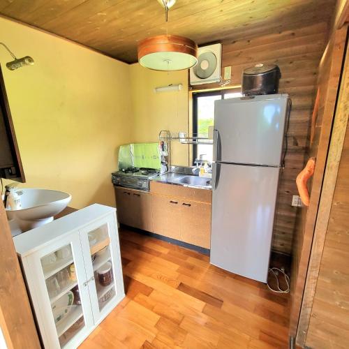 a kitchen with a refrigerator and a sink at koco in Nishinoomote