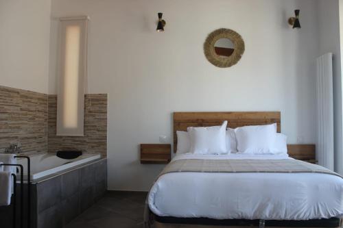 - une chambre avec un grand lit et une baignoire dans l'établissement El Cobijo de Gredos, à Navaluenga