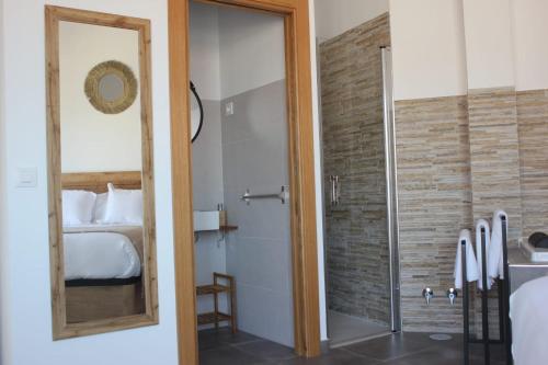 La salle de bains est pourvue d'une douche, d'un lit et d'un miroir. dans l'établissement El Cobijo de Gredos, à Navaluenga