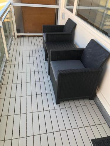 a balcony with two chairs and a table at Appartement 1 chambre De Haan in De Haan