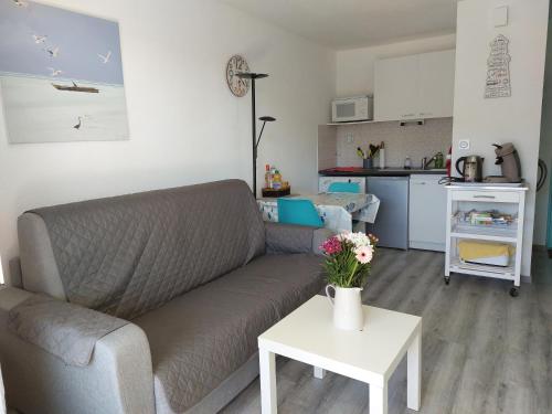 sala de estar con sofá y mesa en Appartement T 2 AVEC PISCINE, en Lacanau