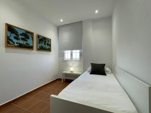 a white room with a bed and a window at El Mirador del Coto in Sanlúcar de Barrameda