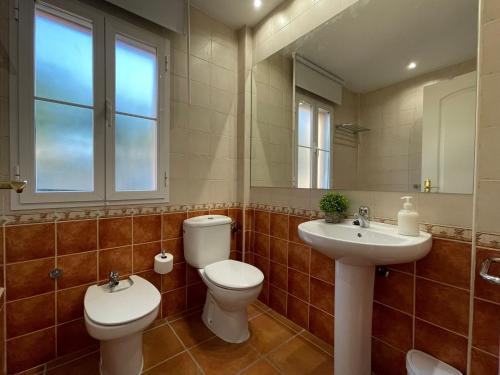 a bathroom with two toilets and a sink and a mirror at El Mirador del Coto in Sanlúcar de Barrameda