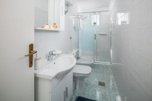 biała łazienka z toaletą i umywalką w obiekcie Apartments by the sea Zambratija, Umag - 2557 w mieście Zambratija