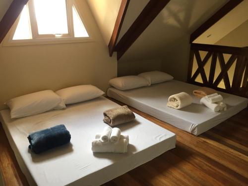 two beds in a room with towels on them at Elliannah Pines Hotel in Baguio