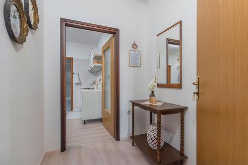 a hallway with a table and a mirror and a door at Apartments with a parking space Novigrad - 2536 in Novigrad Istria