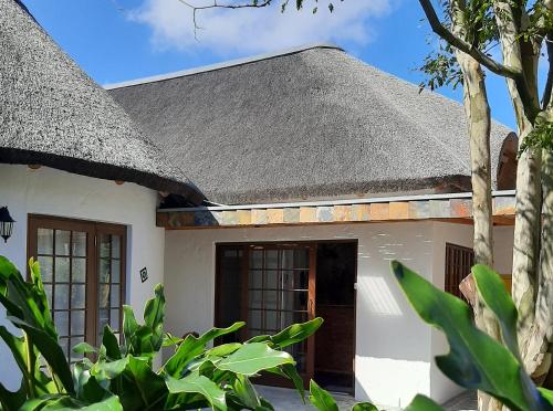 a white house with a black roof at Badger's Lodge in Knysna
