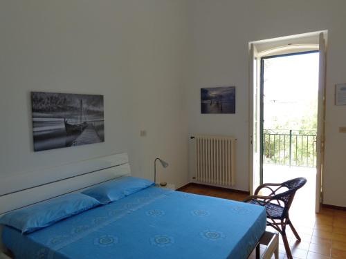 a bedroom with a bed and a chair and a window at Villa Stasi B&B in Leuca