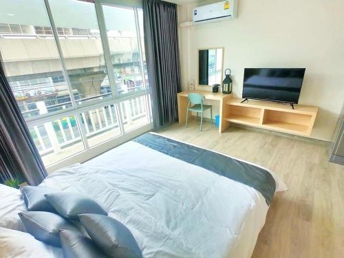 a bedroom with a bed and a large window at El Huq in Bangkok
