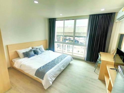 a bedroom with a large bed and a large window at El Huq in Bangkok